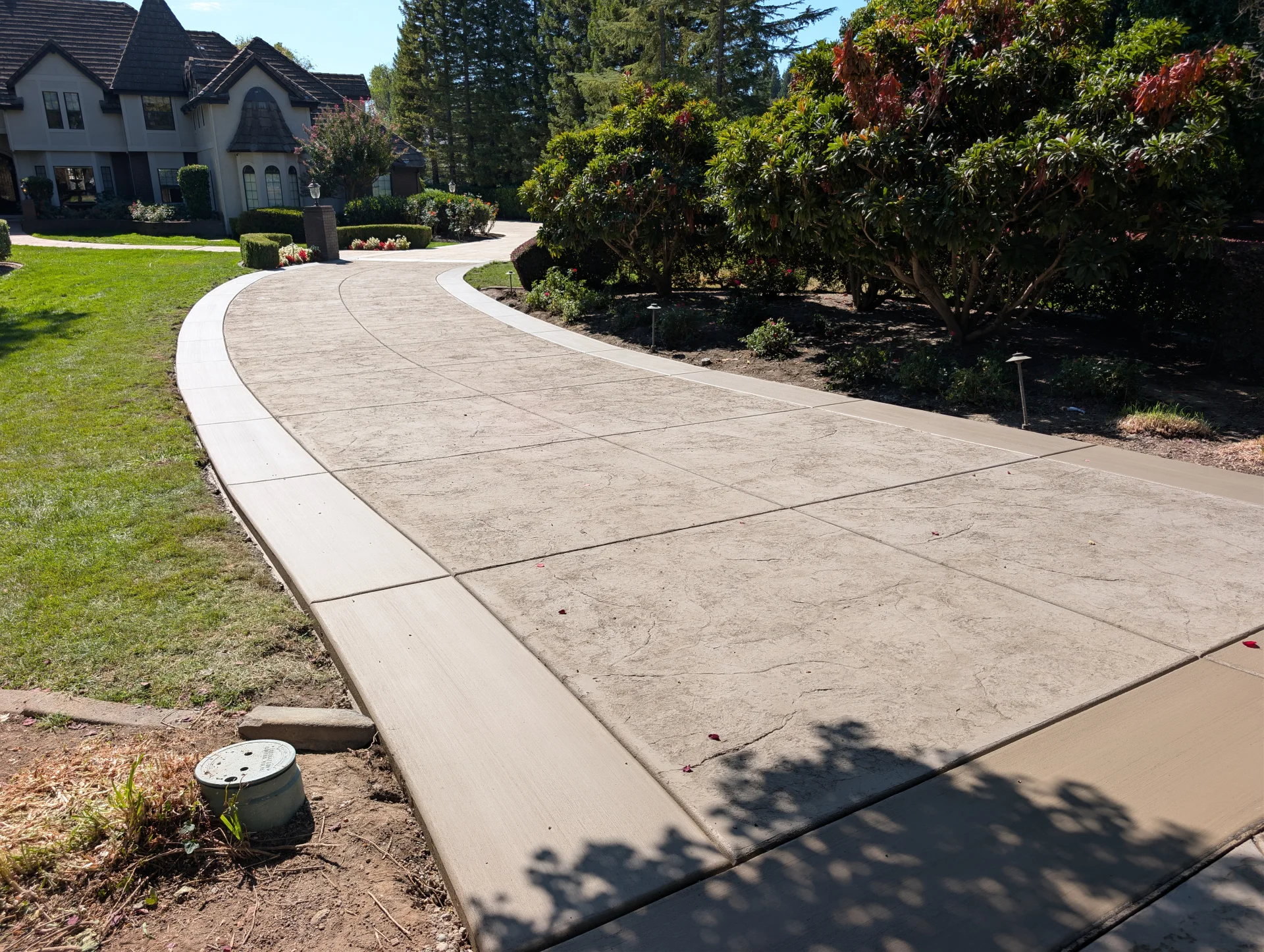 Finished curved stamped concrete driveway with clean borders at a Granite Bay home