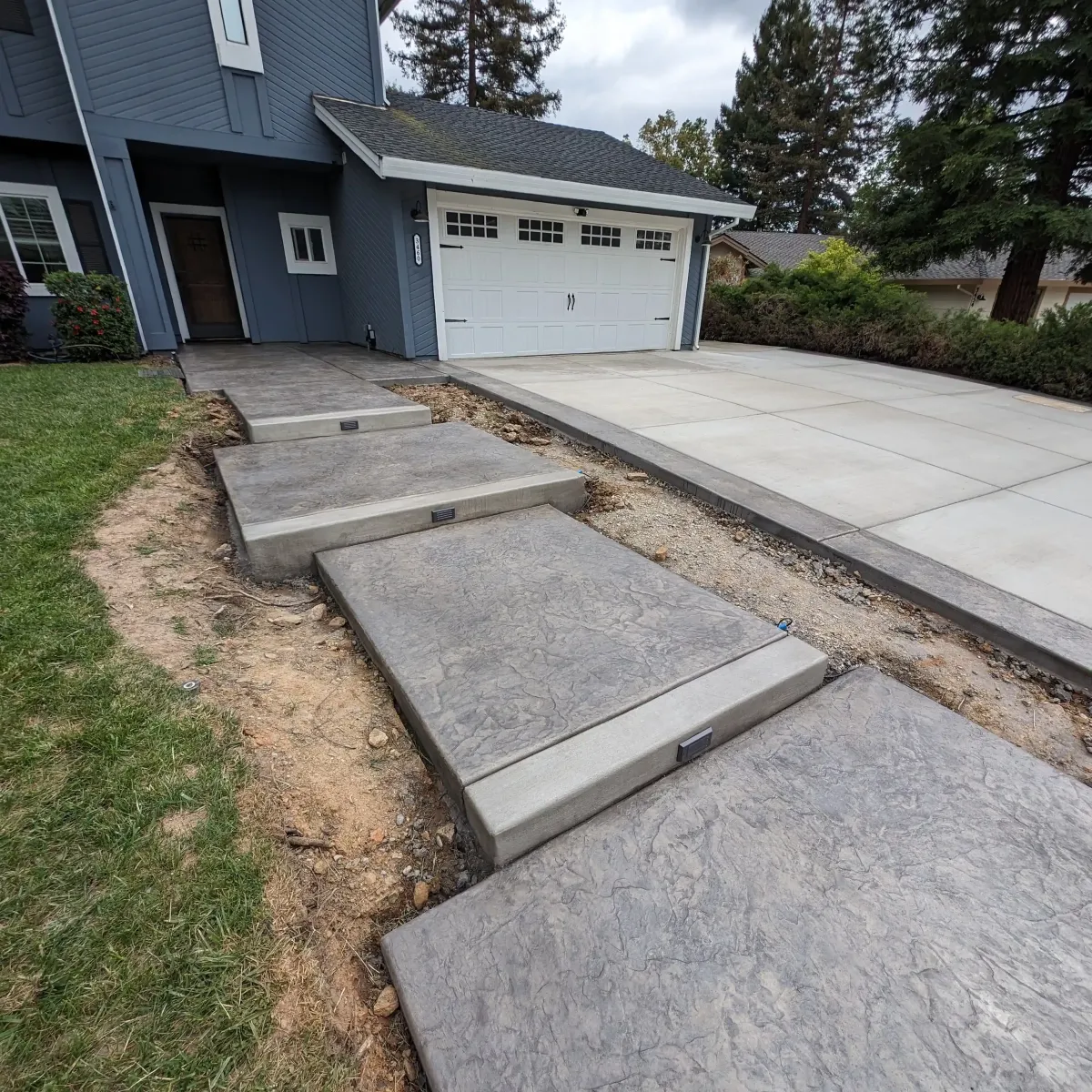 Concrete walkway connecting spaces beside a home